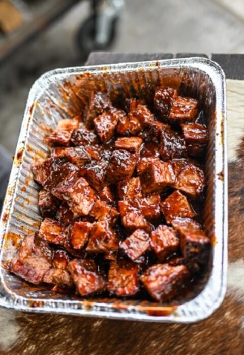 Finished glazed brisket burnt ends in an aluminum pan