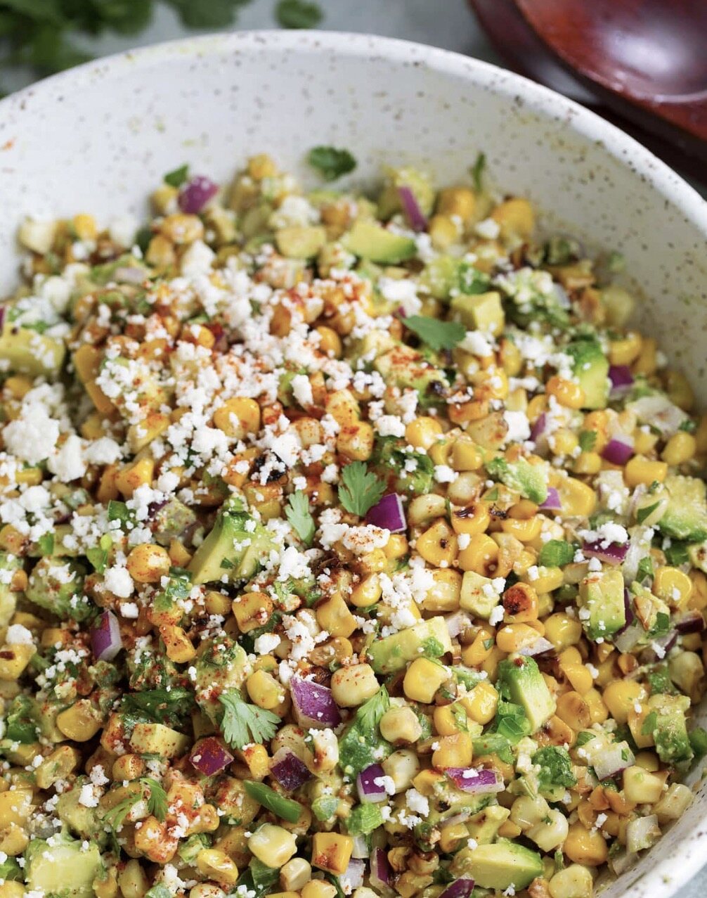 Representative serving of creamy street corn salad with cotija, jalapeño, scallions and cilantro